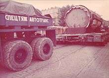 Truck and trailer transporting large base of a statue