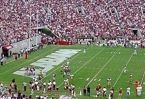 American football players near the end zone near the goal line.