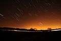 Short streaks of light on a dark sky, showing star trails that were photographed with a long exposure.