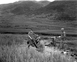 Men stand around a mortar high on a mountain