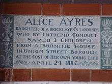 A tablet formed of six standard sized tiles, bordered by green flowers in the style of the Arts and Crafts movement