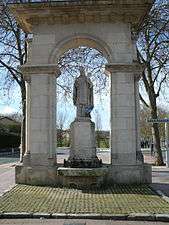 Statue of a bishop under a stone arch