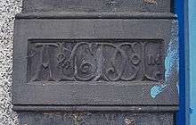 The initials AL&GD Co Ltd in ornate script, carved into a flat column