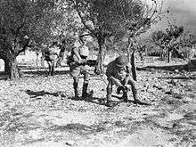 Soldiers set up a machine gun in a wooded area