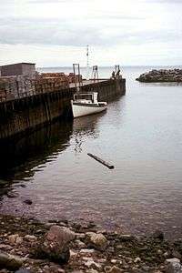 Photo of boat in water next to a dock