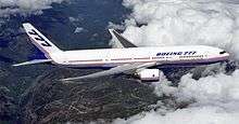 Aircraft in flight, surrounded by white clouds. Side view of twin-engine jet in the sky.