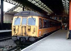 Yellow-and-black locomotive at a covered station