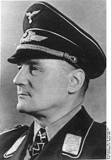 A man wearing a peaked cap and military uniform with an Iron Cross displayed at the front of his uniform collar.