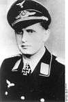 A man wearing a peaked cap and military uniform with an Iron Cross displayed at the front of his uniform collar.