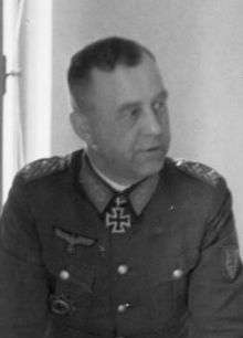 A man wearing a military uniform with an Iron Cross displayed at the front of his uniform collar.