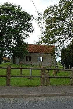 a small simple rectangular chapel with a red tiled roof