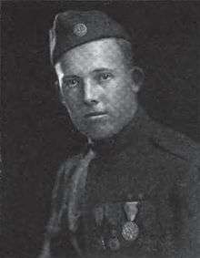 Head and shoulders of a young man in a military uniform with an array of medals on his chest and a garrison cap with a "US" button.