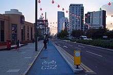 Wide cycle lane separated from traffic by raised curb.