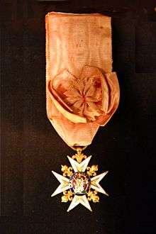 A neck-style military order: an elaborate cross with jewels and gold hangs from an orange ribbon