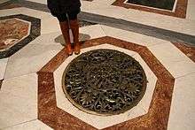 White and orange marble rings a circular, decorated bronze vent