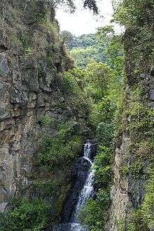 Small waterfall sided by two large rocks.