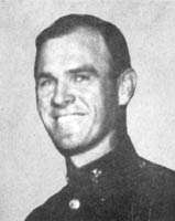 A black and white headshot of Hayden in his military dress uniform without a hat and smiling.