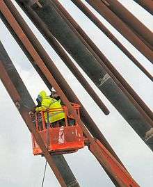 man on lift basket dismantling the B of the Bang