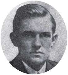 Round portrait of a young man dressed in a suit and with neatly combed hair.