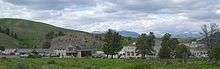 A group of buildings with trees and hills in background