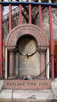 Photograph of a granite drinking fountain inscribed, "Replace the cup"