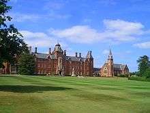 broad neo-gothic building and chapel with manicured grounds