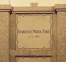 A marble gravestone on the wall of a crypt