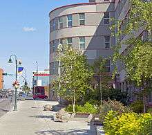 A view along the front of the building, in which we can see some of the street and buildings nearby in the background