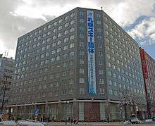 Photograph of a grey eleven-storey office building on a street corner