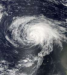 A visible satellite image of a well-organized Category 1 hurricane near peak intensity in the eastern Atlantic.