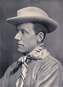 A profile photograph of a thin, clean-shaven man in his mid-thirties. His facial features are somewhat angular. He wears a brimmed hat and neckerchief.