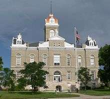 Two-story stone building with one-story clock tower above