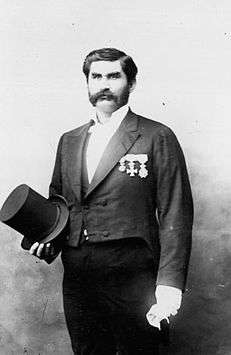 Photograph of men in suit holding top hat