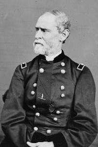 Man with gray beard and facing left in uniform with two vertical columns of buttons