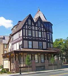 A brown and cream colored building with peaked and pointy roofs