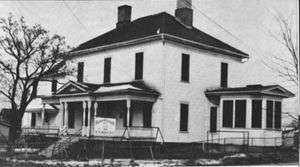 A photograph of a wooden frame house.