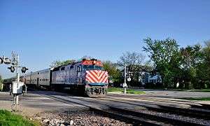 Locomotive on middle of three tracks at level crossing