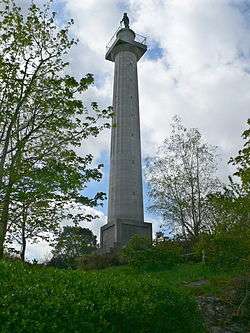 A tall column on a small base, surmounted by a statue