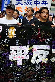 Chinese marchers holding up a black signed banner '平反六四'sign in the background reads "Heaven destroy the Communist party"