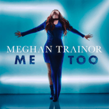 Meghan Trainor stands with her hands spread far apart while wearing a long, blue dress in front of a shiny blue background.