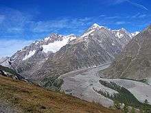 a glacier covered with rocky debris flowing down the Italian side of Mont Blanc