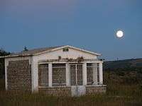 Large white concrete tomb in a grassy field in Madagascar