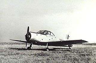 Single-engined military monoplane parked on airfield