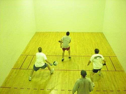 Four men playing paddleball