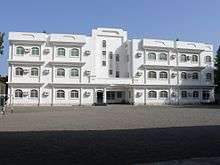 White, rectangular building with many windows