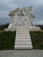 White stone memorial, with steps and people escaping