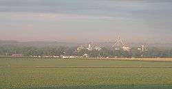 Town with grain elevators; crop field in foreground