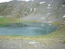 Looking down on Summit Lake during the late summer with a few patches of snow still visible on the rock glacier in the backgound