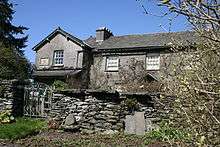 A house in the middle distance, a garden wall and gate