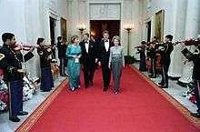 The Reagans and the Clintons walking a red carpet during the 1987 Dinner Honoring the Nation's Governors